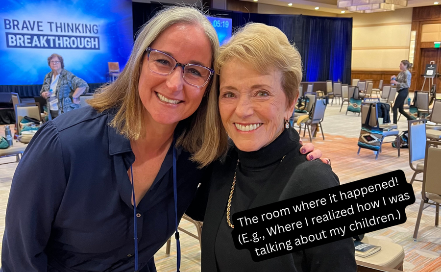 Two women smiling at a “Brave Thinking Breakthrough” event in a hotel ballroom.